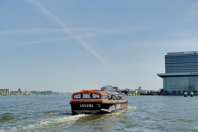 Amsterdam 1h Canal Cruise by Semi-Open Boat with Audio Guide - Munt Tower from afar and how gates shape the city