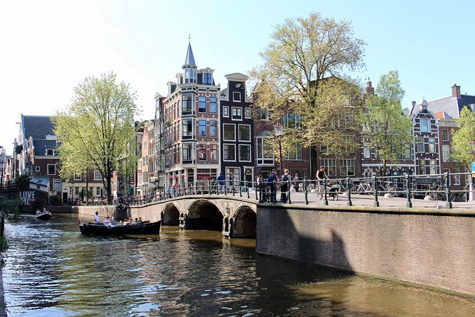 Amsterdam Canal Tour by Open Boat – 90 min Small Group Experience - Munt Tower and the canal border experience near De Wallen
