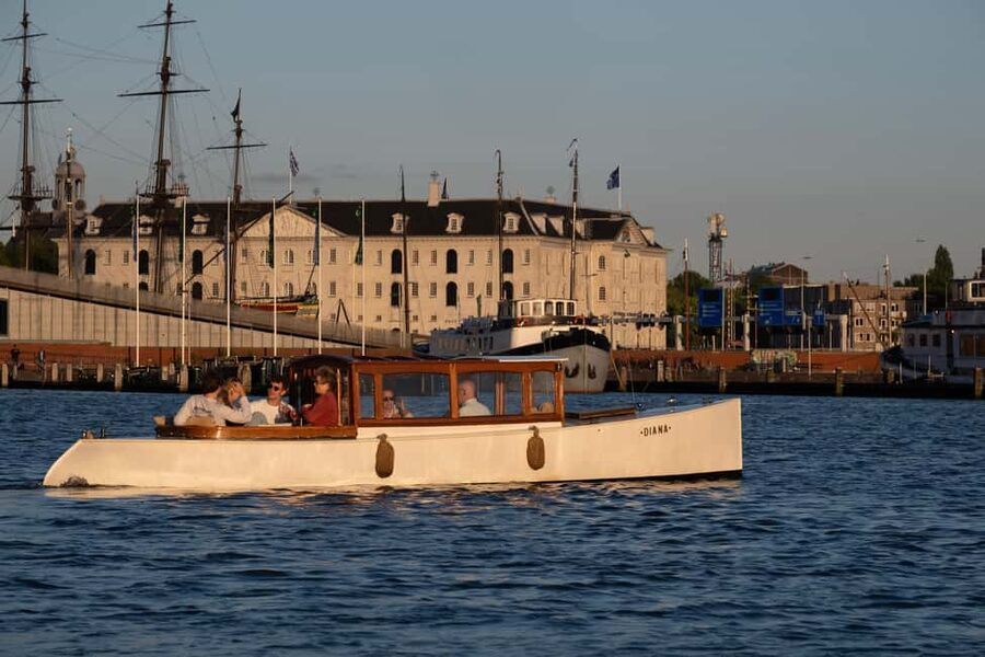 Amsterdam: Hidden Gems Canal Cruise - Meeting the boat at the wooden dock and getting set for a cozy ride